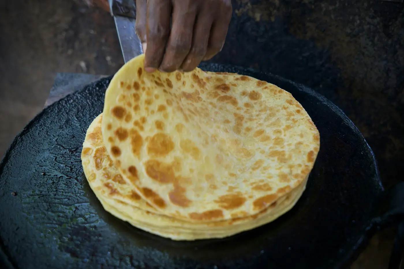 Paratha cooking on a tawa